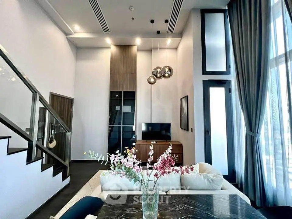 Luxurious modern living room with high ceilings and elegant decor in a stylish apartment.