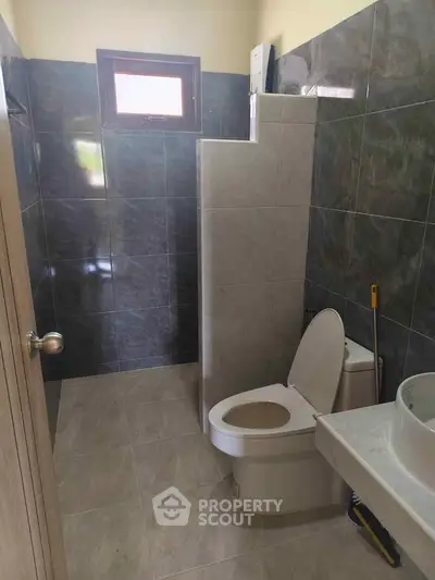 Modern bathroom with sleek tiles and natural light from window