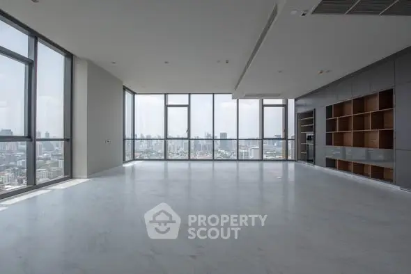 Spacious modern living room with panoramic city views and sleek built-in shelving.
