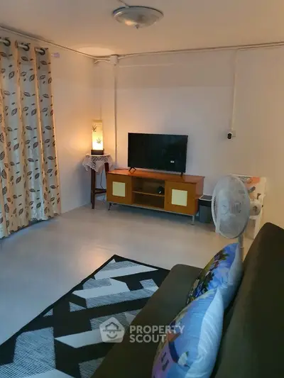 Cozy living room with modern decor, TV setup, and stylish lighting, perfect for relaxation.