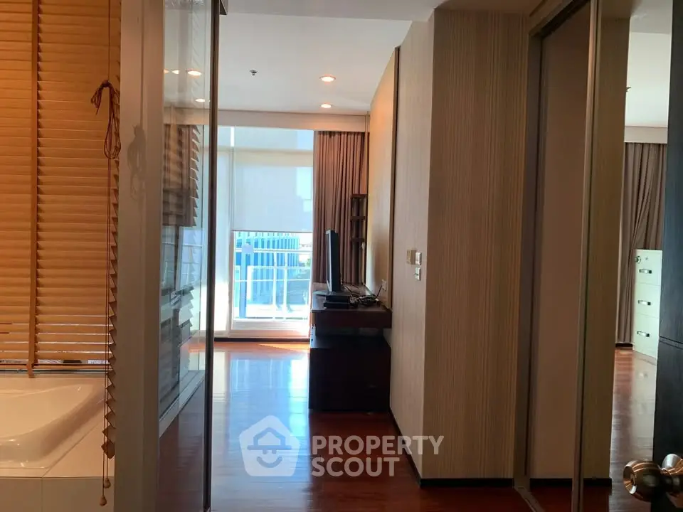 Modern apartment hallway with wooden flooring and natural light