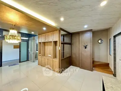 Spacious modern living area with elegant chandelier and wooden accents