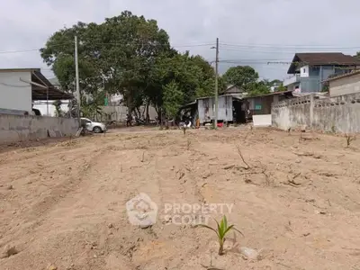 Vacant land plot with potential for development in a residential area, surrounded by houses and trees.
