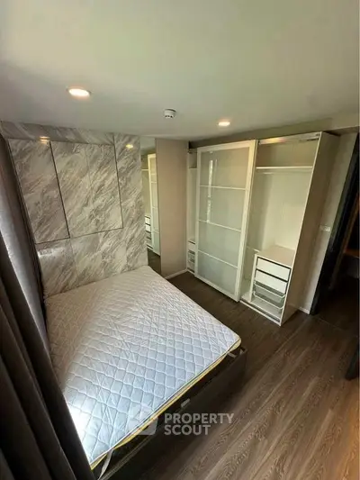 Modern bedroom with stylish wardrobe and wooden flooring