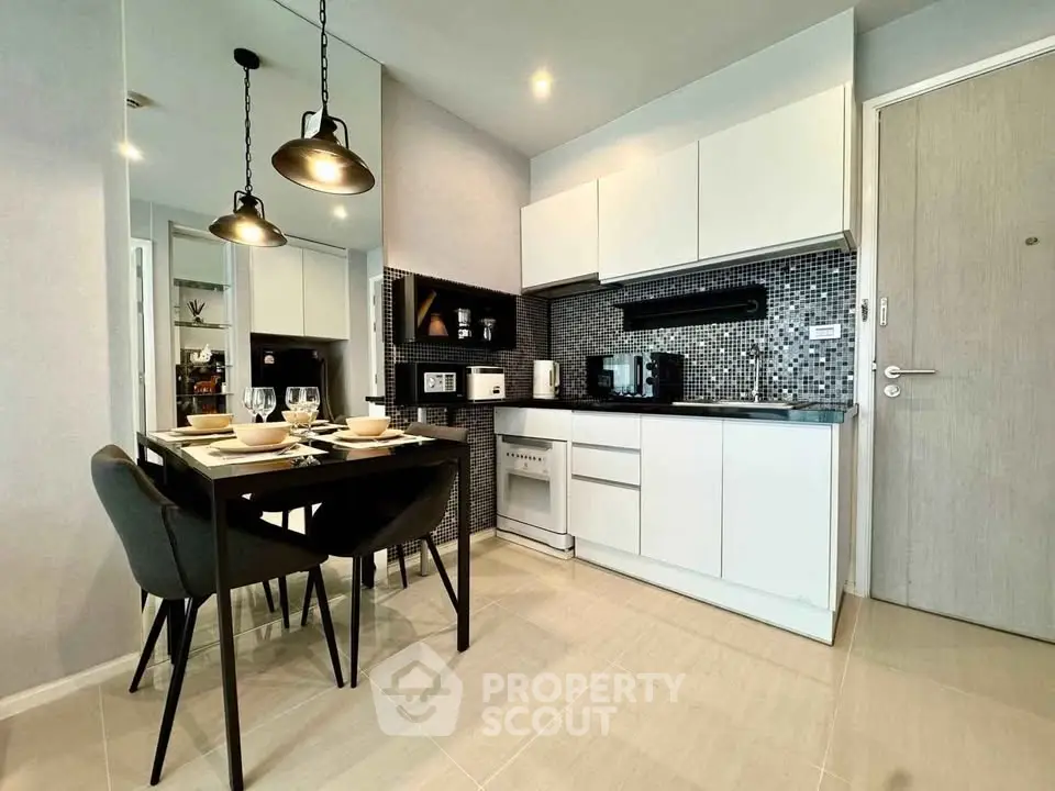 Modern kitchen with sleek cabinetry and dining area in contemporary apartment