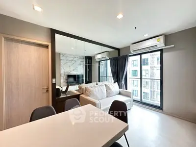 Modern living room with large windows and stylish decor in a high-rise apartment.