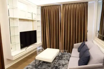 Modern living room with sleek TV unit and cozy sofa in elegant apartment.