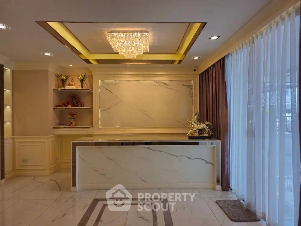 Luxurious marble reception area with elegant chandelier and decorative accents