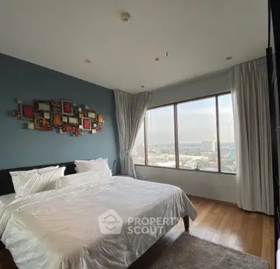 Spacious bedroom with large window offering stunning city views and modern decor.