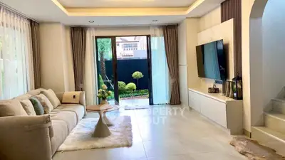 Spacious modern living room with elegant decor and garden view, perfect for relaxation and entertainment.
