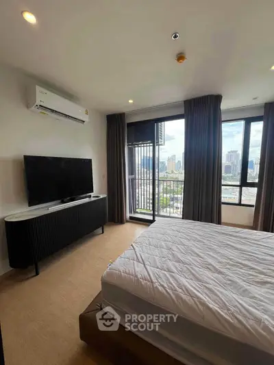 Modern bedroom with city view, featuring large windows, air conditioning, and sleek furniture.