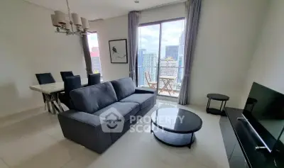 Modern living room with city view, stylish furniture, and natural light in a high-rise apartment.