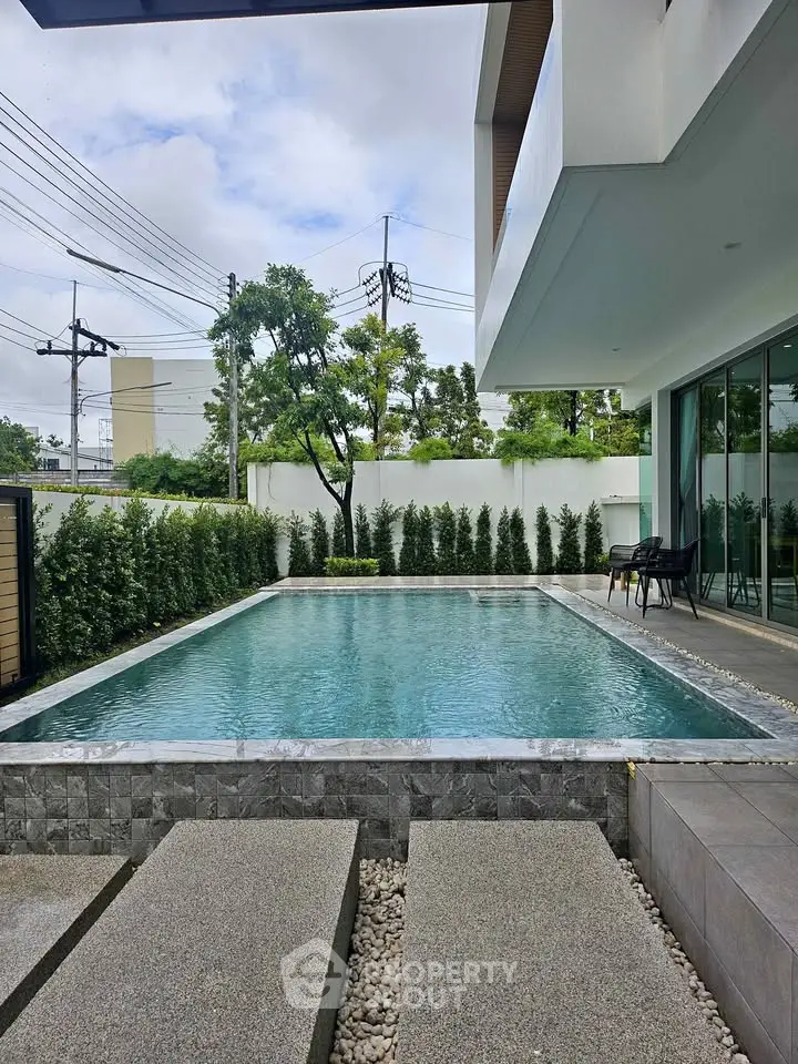 Luxurious modern home with private pool and stylish outdoor seating area, perfect for relaxation and entertainment.