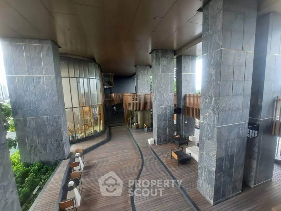 Luxurious modern building entrance with elegant wooden flooring and stylish seating area.