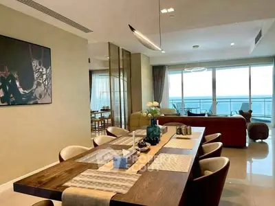 Luxurious open-plan living and dining area with ocean view, modern decor, and elegant furnishings.