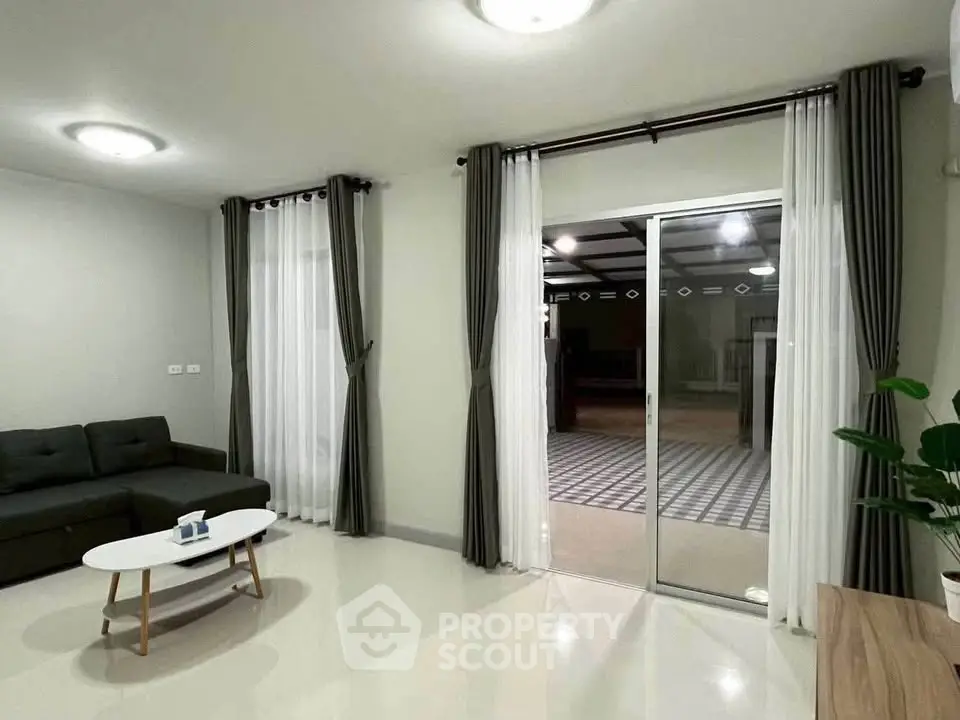 Spacious living room with modern decor and large sliding glass doors leading to a patio.