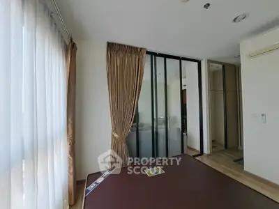 Modern bedroom with large windows and sliding glass doors in a stylish apartment.
