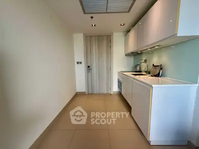 Modern minimalist kitchen with sleek white cabinets and integrated appliances in a compact layout.