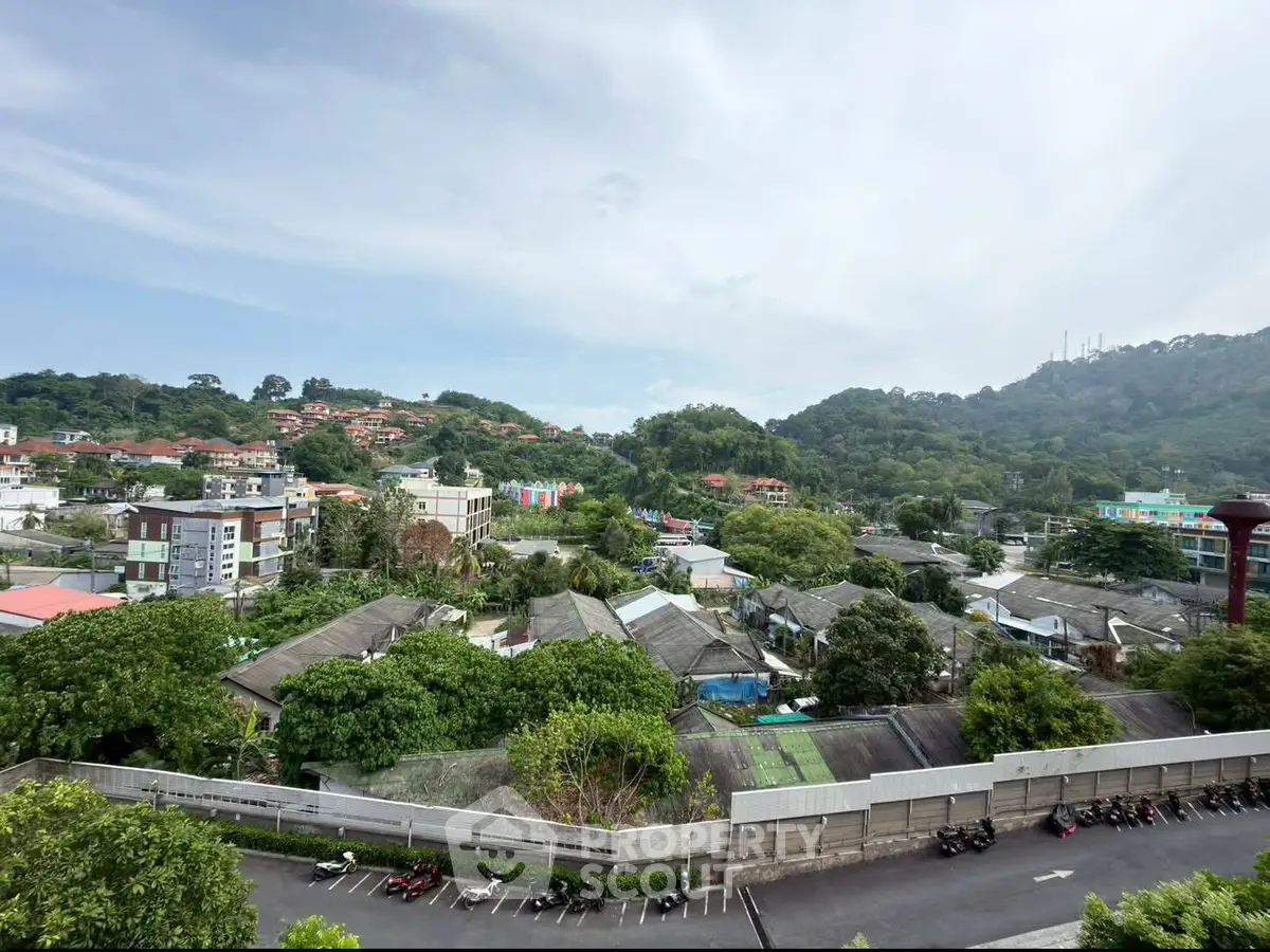 Scenic view of lush green hills and residential area from a high vantage point.