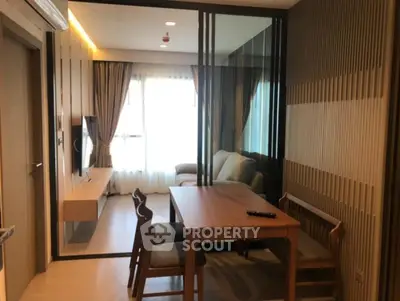 Modern living room with stylish wooden dining set and cozy sofa, featuring elegant lighting and floor-to-ceiling windows.