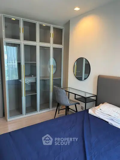 Modern bedroom with stylish glass wardrobe and sleek study desk