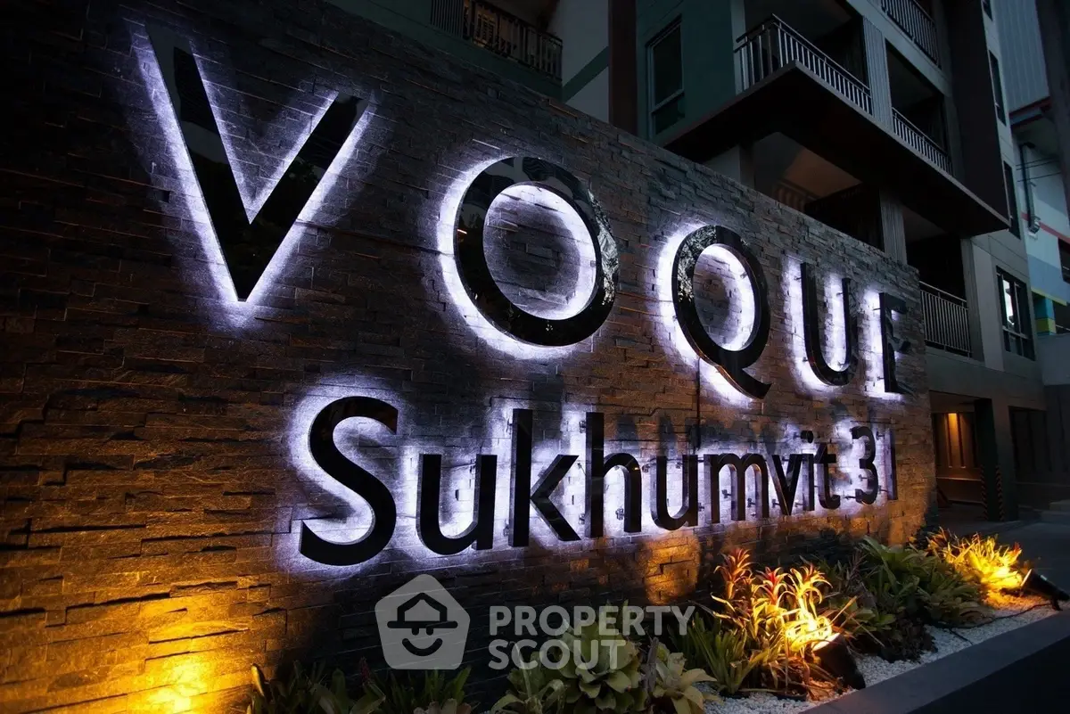 Elegant facade of Voque Sukhumvit 31 with illuminated signage and lush landscaping.