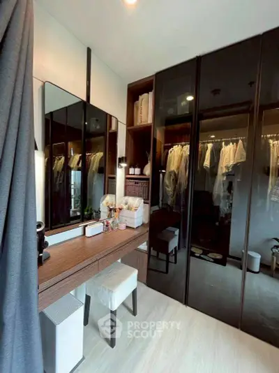 Stylish bedroom with modern walk-in closet and elegant vanity area.