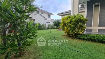 Spacious garden area with lush greenery and modern house exterior