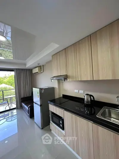 Modern kitchen with sleek cabinets, stainless steel appliances, and balcony view.
