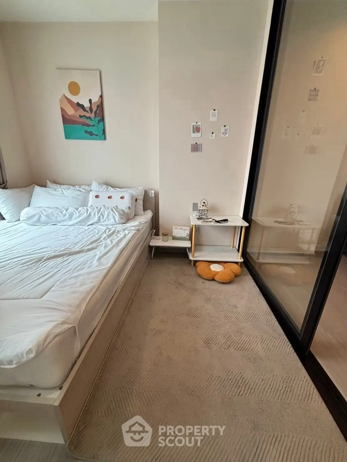 Cozy bedroom with modern decor and large glass sliding door, perfect for relaxation.