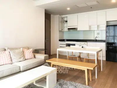 Modern open-plan living room and kitchen with sleek furniture and bright decor.
