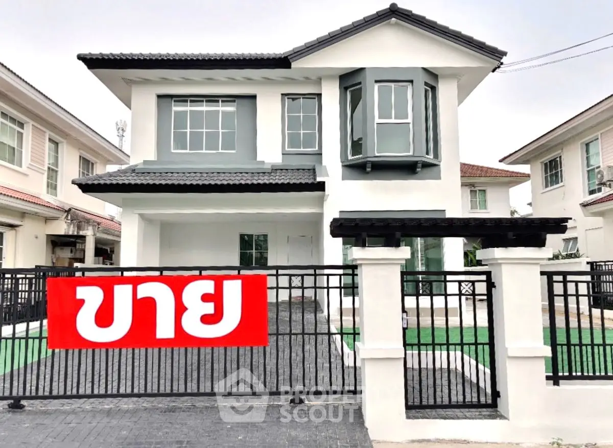 Modern two-story house with a gated entrance and a prominent for sale sign.