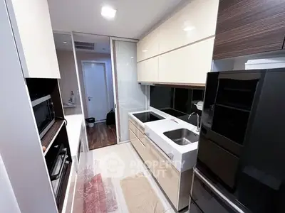 Modern kitchen with sleek cabinetry and dual sinks in a compact layout.
