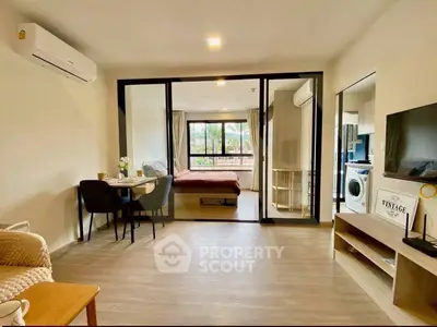 Modern open-plan living room with dining area and bedroom view