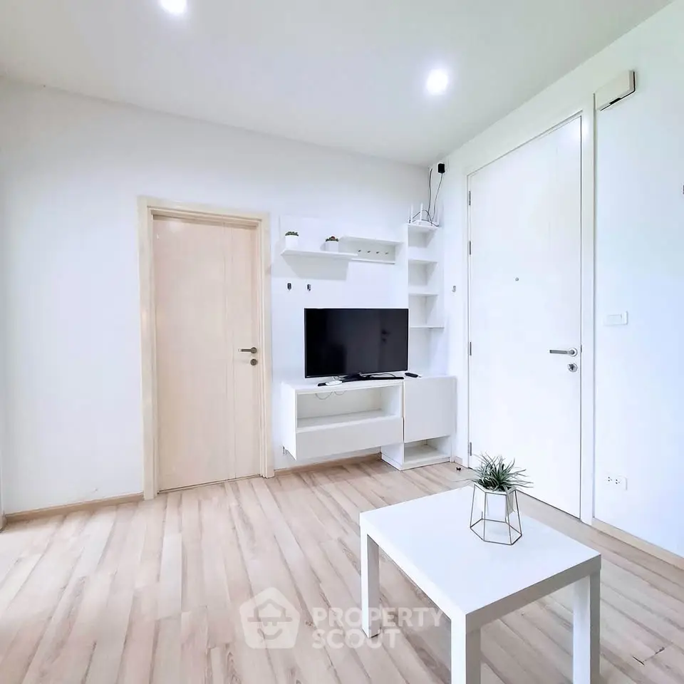 Modern minimalist living room with white furniture and wooden flooring