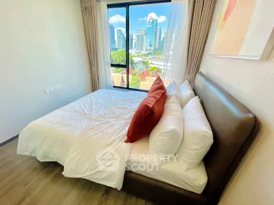 Modern bedroom with city view, featuring a cozy bed and large window in a high-rise apartment.