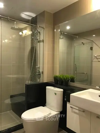Modern bathroom with glass shower and sleek fixtures in a contemporary apartment.