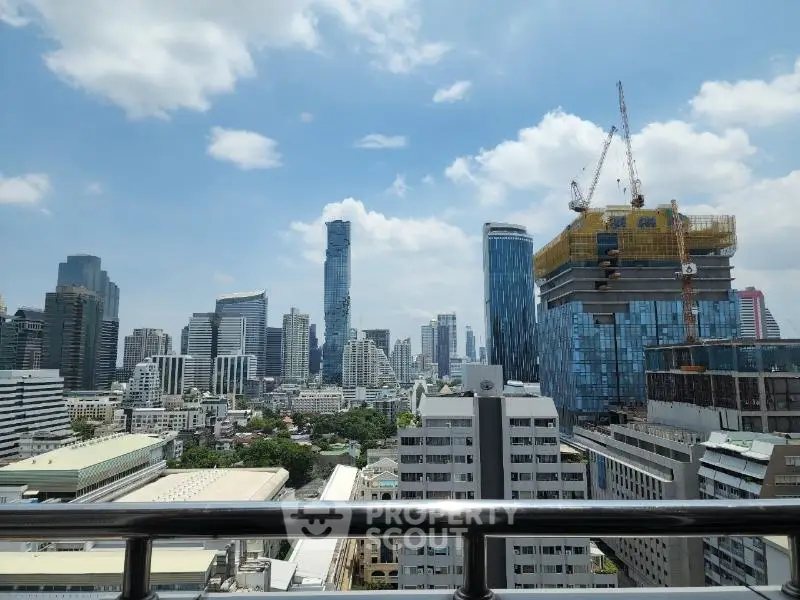 Stunning cityscape view from a high-rise balcony showcasing modern skyscrapers and construction in a vibrant urban setting.
