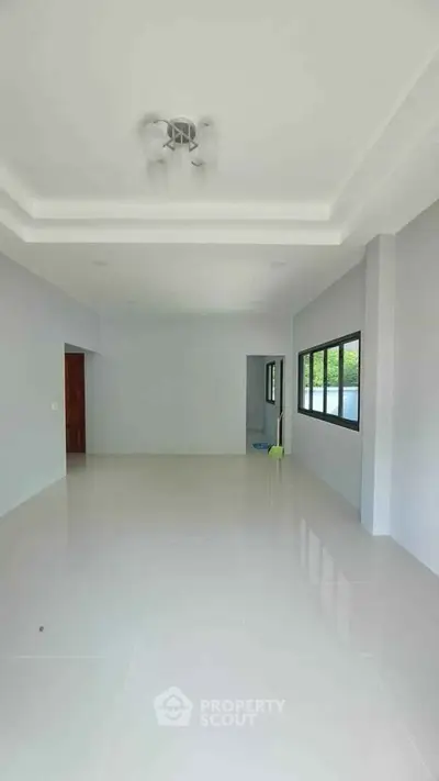 Spacious empty room with large windows and glossy tiled floor, perfect for customization.
