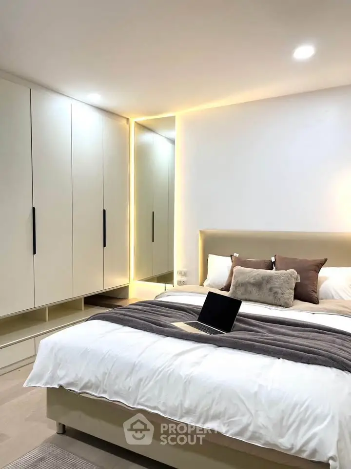 Modern bedroom with sleek wardrobe and cozy bed setup