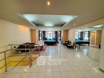 Spacious open-plan living area with modern furnishings and large windows.