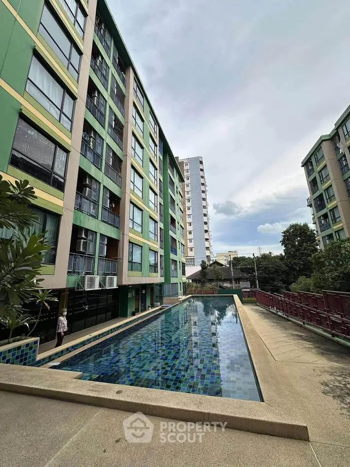 Modern apartment complex with outdoor pool and lush greenery
