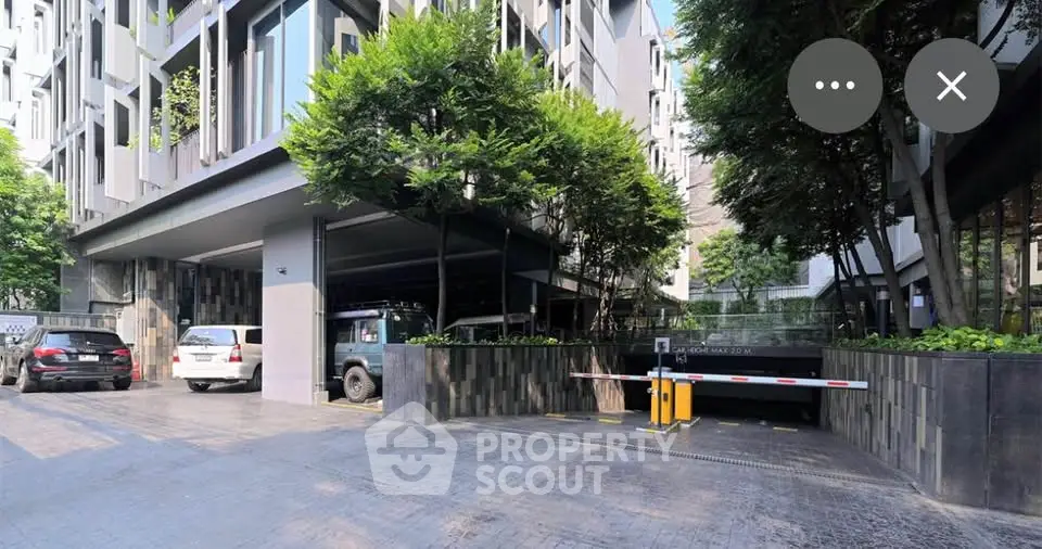 Modern building entrance with lush greenery and secure parking access