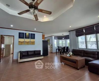 Spacious living room with modern furniture and ceiling fan in a bright, open layout.