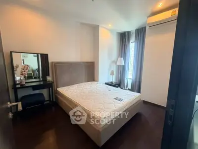 Modern bedroom with elegant decor and natural light, featuring a comfortable bed and stylish furnishings.