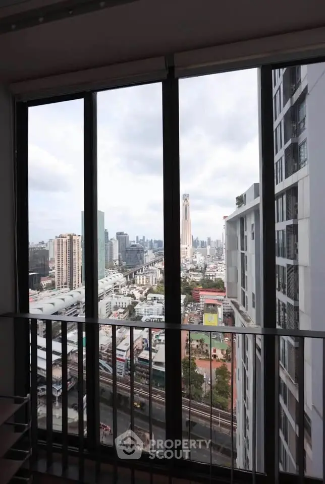 Stunning cityscape view from high-rise apartment window, showcasing urban skyline and modern architecture.