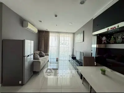 Modern living room with sleek design, featuring a large sofa, flat-screen TV, and floor-to-ceiling windows.