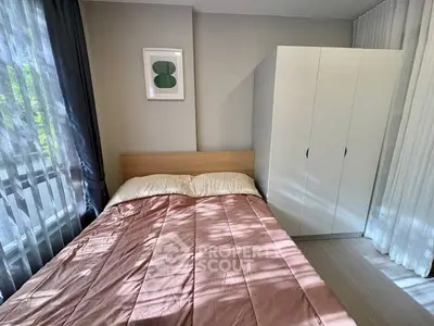 Cozy bedroom with natural light, featuring a comfortable bed and spacious wardrobe.