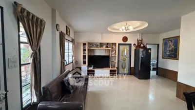 Spacious living room with modern decor and natural light, featuring a stylish entertainment center and elegant furnishings.