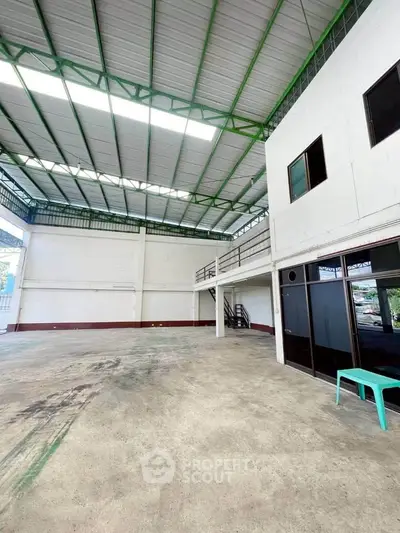 Spacious industrial warehouse with high ceilings and ample natural light, perfect for storage or manufacturing.